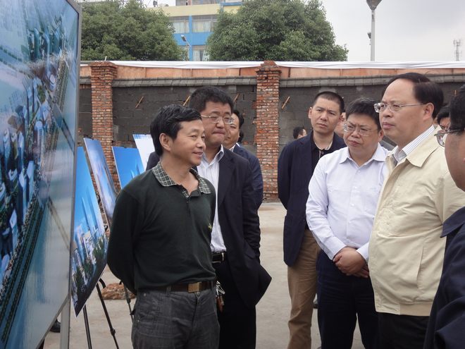 时任公司董事长吴建松（左一）向时任长沙市委副书记、市长张剑飞、长沙市雨花区区委书记周杏武汇报红星商圈进展情况